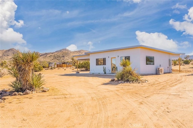 back of house featuring a mountain view and central AC unit