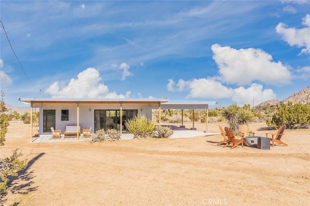 back of property featuring a mountain view and a patio area