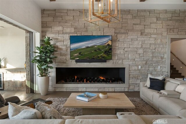 living room featuring a fireplace, hardwood / wood-style floors, and a notable chandelier