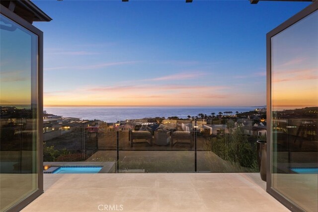 exterior space featuring a water view and a hot tub