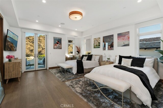 bedroom with access to exterior, hardwood / wood-style floors, and multiple windows