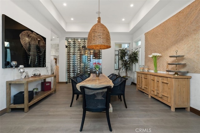 dining space featuring hardwood / wood-style flooring and a tray ceiling