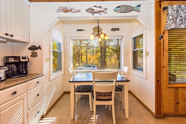 tiled dining space featuring a notable chandelier