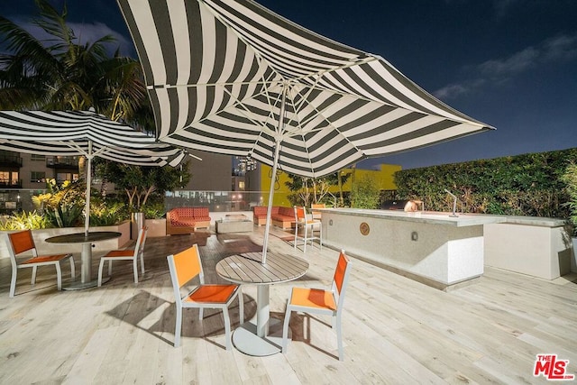 patio at twilight featuring a deck