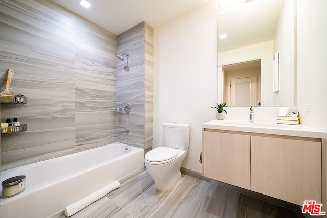 full bathroom featuring tile patterned floors, vanity, tiled shower / bath, and toilet