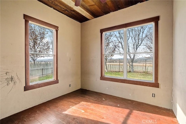 unfurnished room with plenty of natural light, wood finished floors, and wooden ceiling