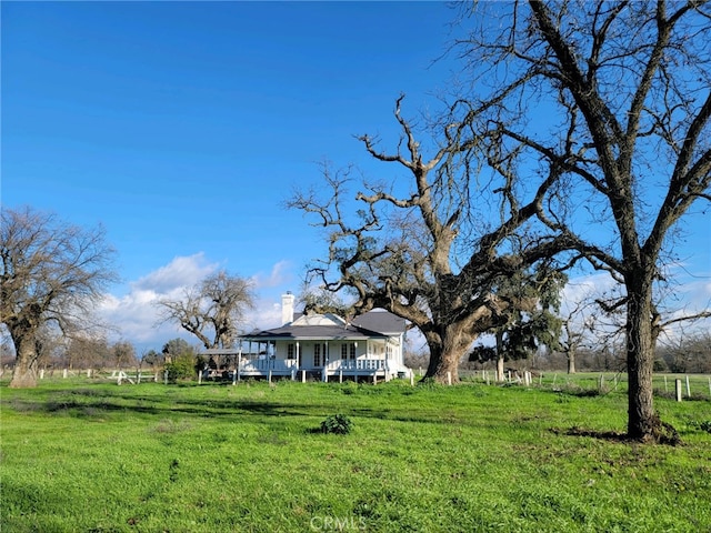 view of yard featuring covered porch and a rural view