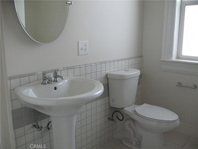 bathroom featuring tile patterned floors, tile walls, and toilet