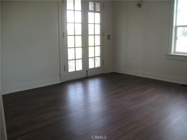 spare room featuring dark hardwood / wood-style flooring and french doors