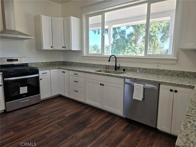 kitchen with dark wood-type flooring, white cabinetry, wall chimney exhaust hood, and light stone counters