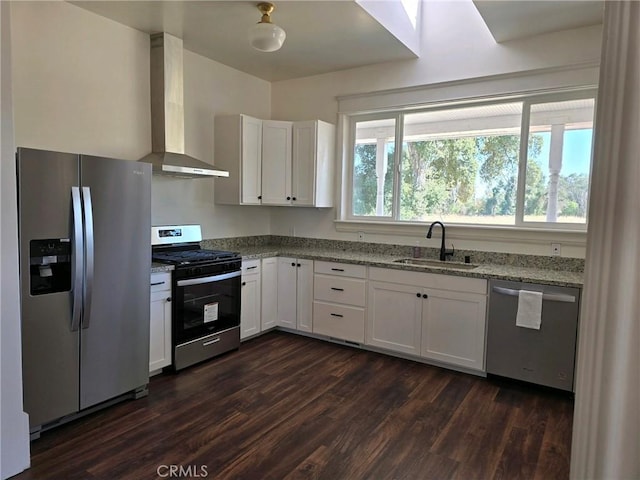 kitchen with white cabinetry, wall chimney range hood, sink, and appliances with stainless steel finishes