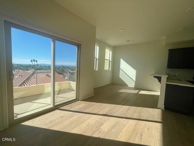 unfurnished living room with sink and hardwood / wood-style flooring