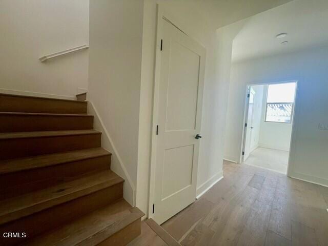 stairs with baseboards and wood finished floors