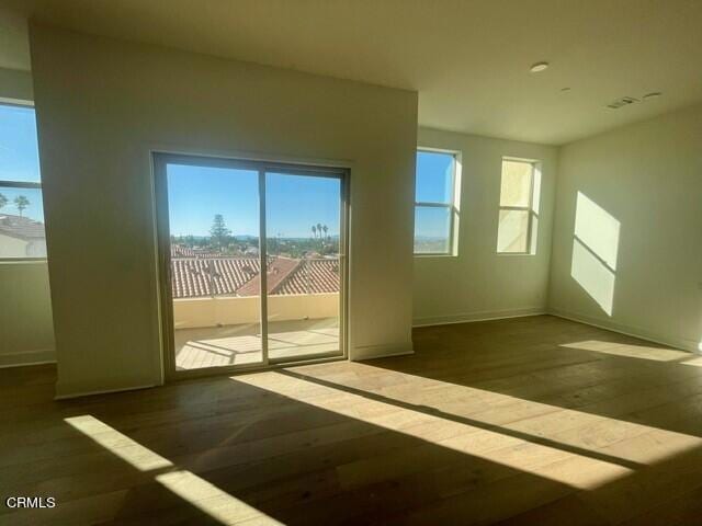 unfurnished room featuring baseboards and wood-type flooring
