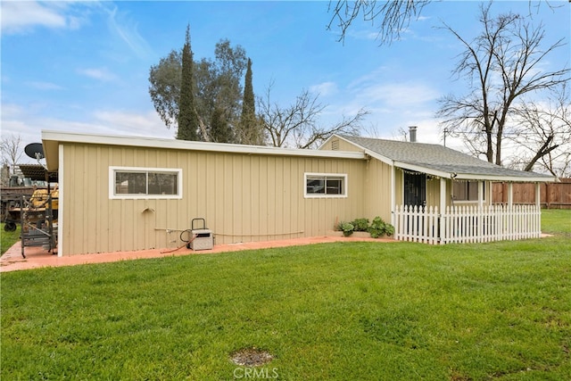 rear view of property with a yard