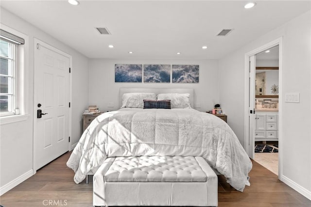 bedroom with ensuite bath and hardwood / wood-style flooring