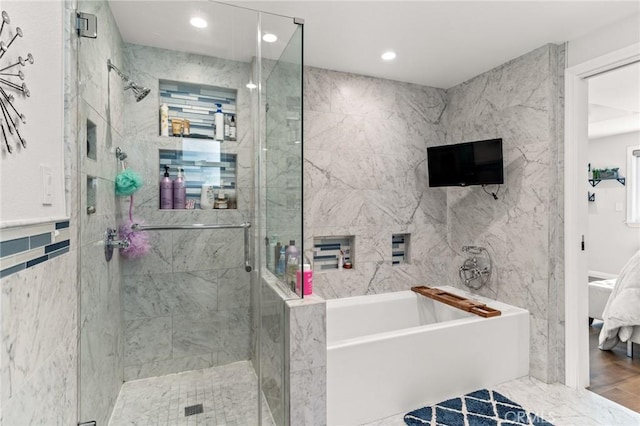 bathroom with hardwood / wood-style flooring, separate shower and tub, and tile walls