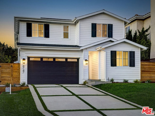 view of front of property featuring a garage and a lawn