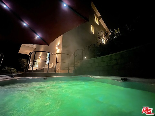 view of pool at twilight