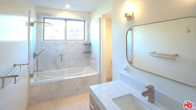 bathroom with vanity and tiled shower / bath combo