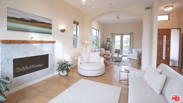 living room with a fireplace, hardwood / wood-style floors, and french doors