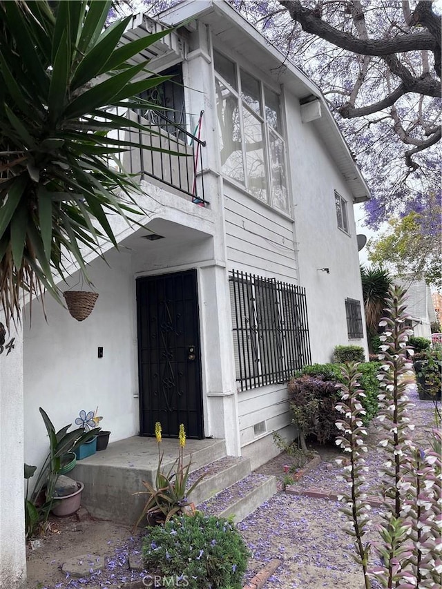 view of exterior entry with a balcony