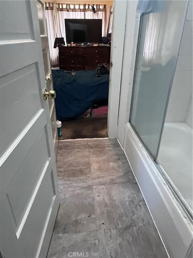 bathroom featuring shower / bath combination with glass door and tile flooring