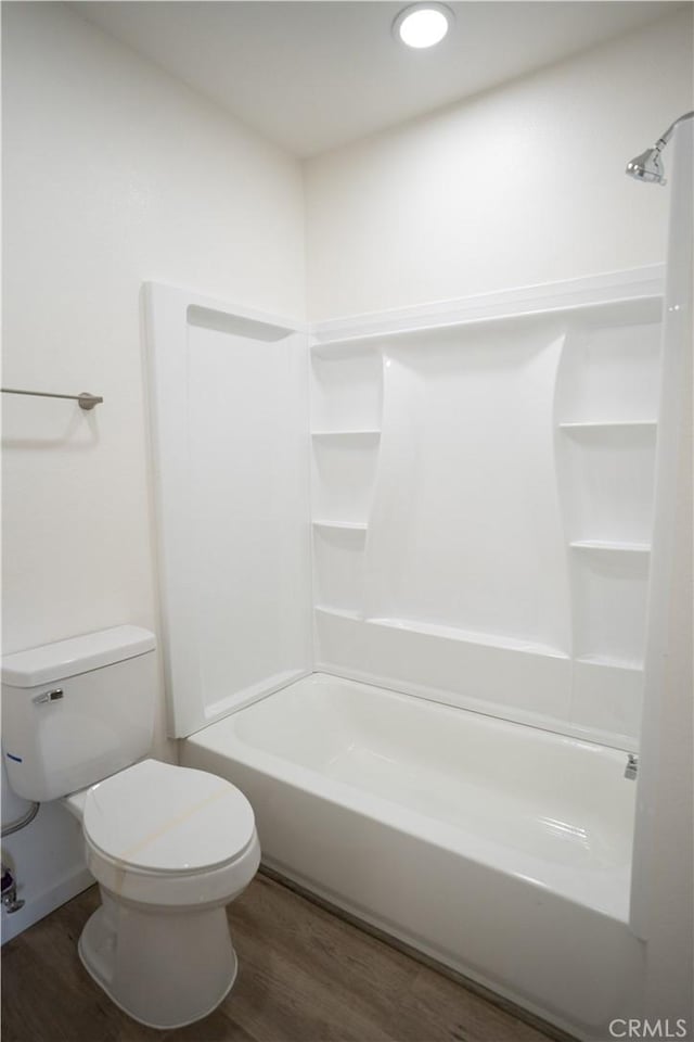 bathroom featuring shower / tub combination, hardwood / wood-style floors, and toilet