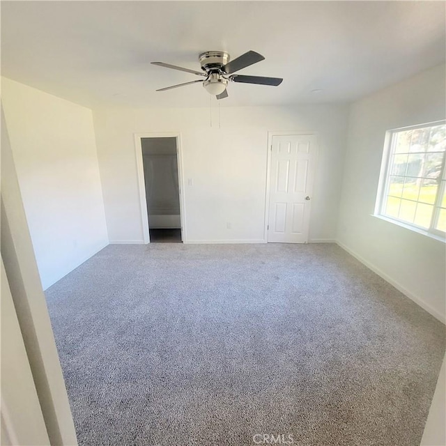 carpeted spare room featuring ceiling fan