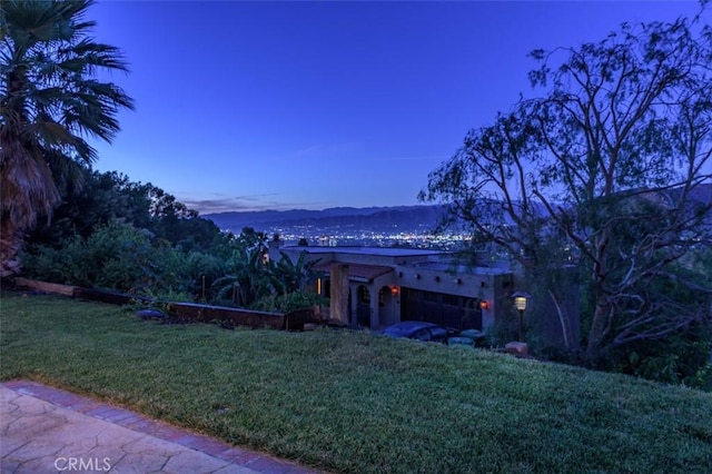 view of front of property with a yard and a mountain view