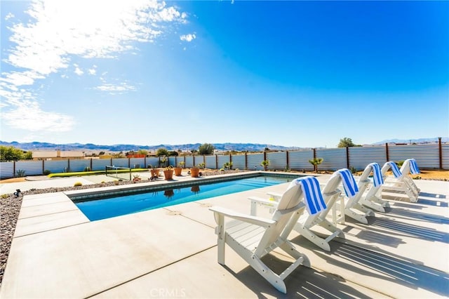 view of swimming pool featuring a mountain view and a patio