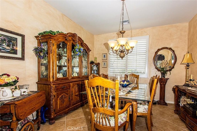 tiled dining room with a notable chandelier