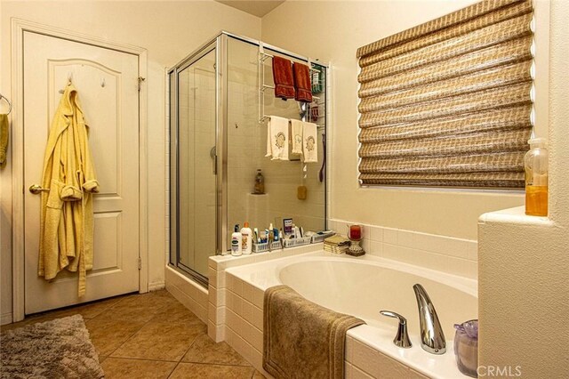 bathroom featuring tile patterned flooring and separate shower and tub