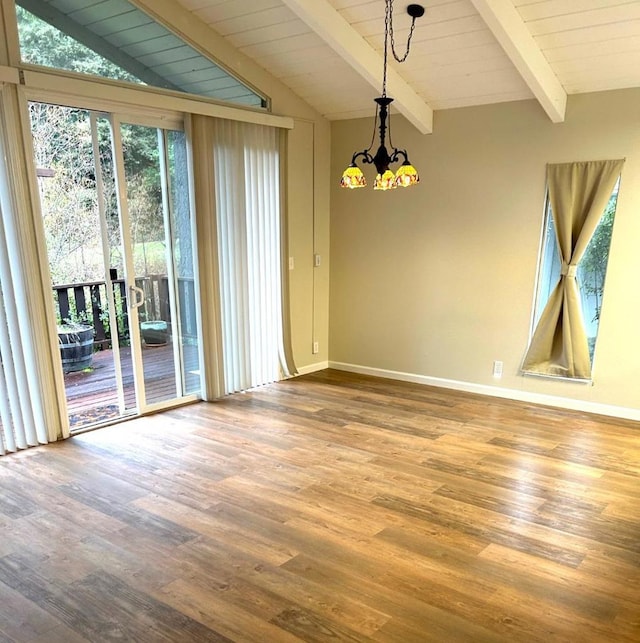 empty room with vaulted ceiling with beams, a chandelier, and hardwood / wood-style floors