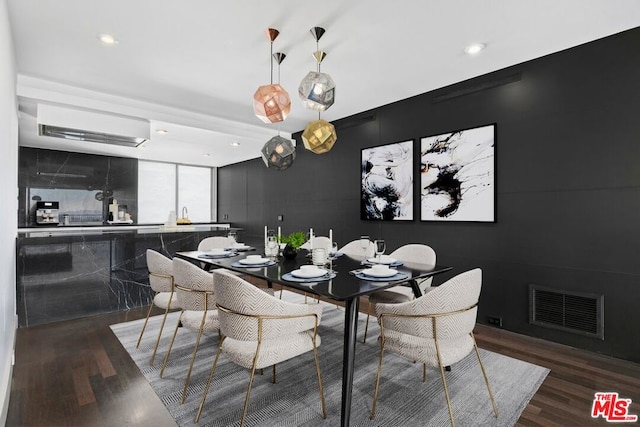 dining area featuring dark hardwood / wood-style flooring and a wall unit AC