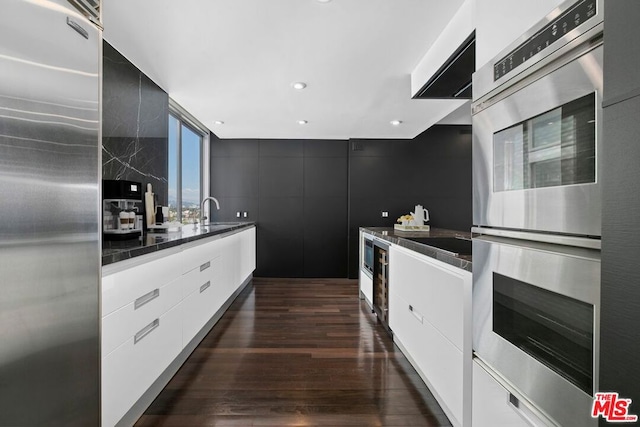 kitchen with white cabinetry, dark hardwood / wood-style flooring, stainless steel appliances, and sink