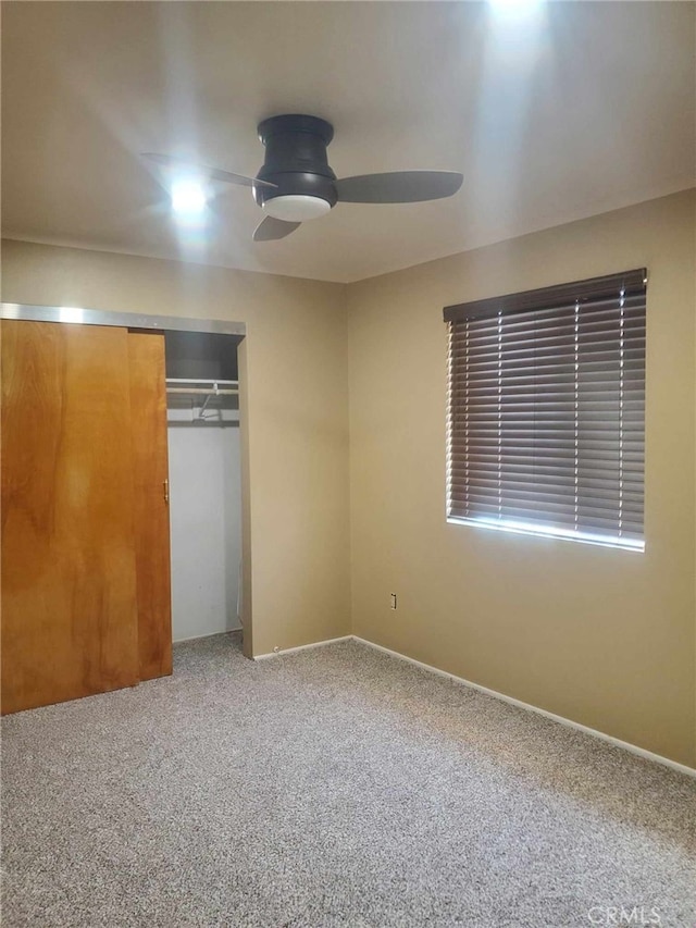 unfurnished bedroom with ceiling fan, a closet, and carpet