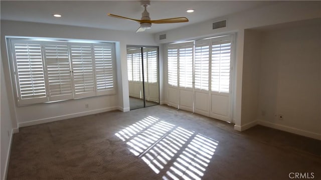 unfurnished bedroom featuring ceiling fan and dark colored carpet