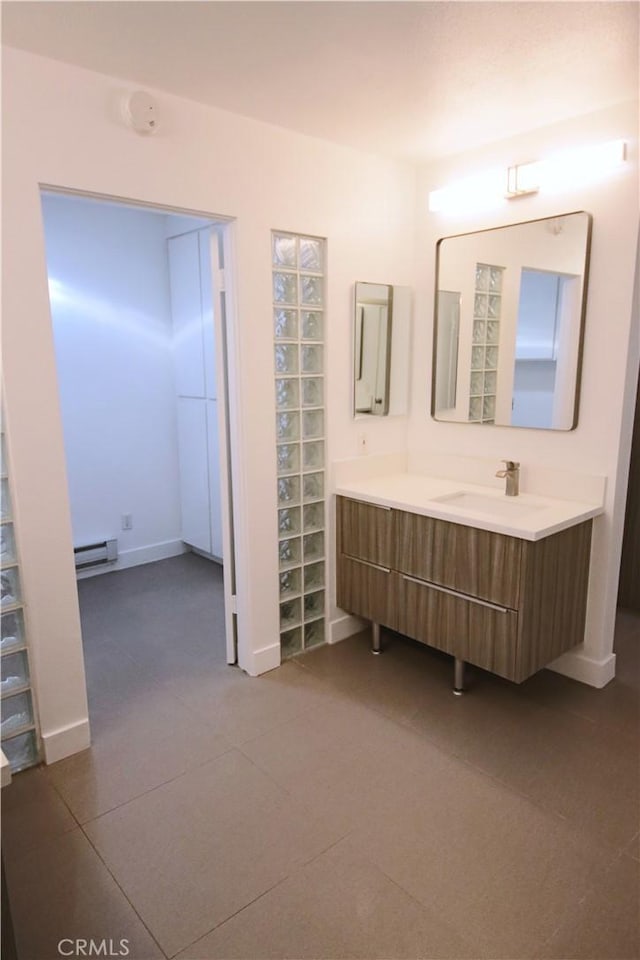 bathroom featuring baseboard heating and vanity