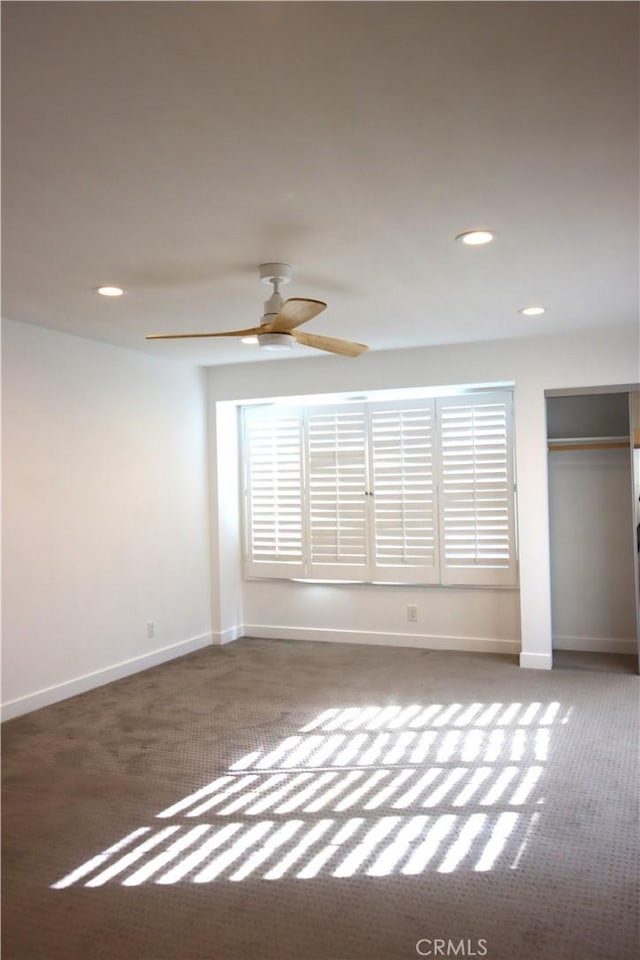 unfurnished bedroom featuring ceiling fan and dark carpet