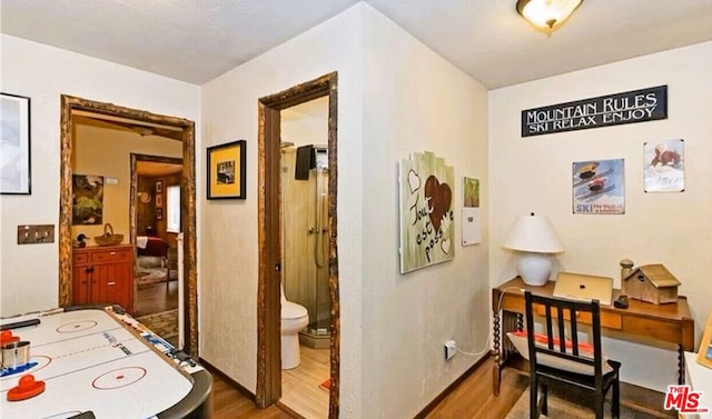 corridor with hardwood / wood-style flooring