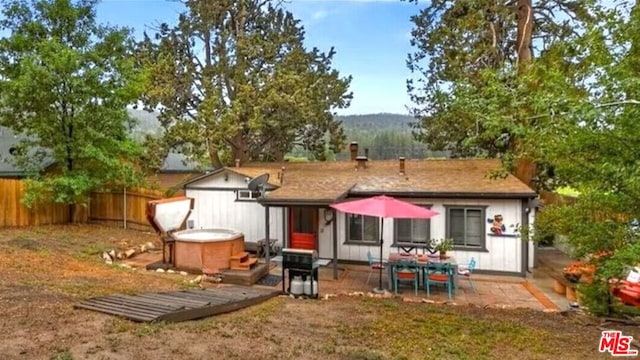 back of property featuring a patio and a shed