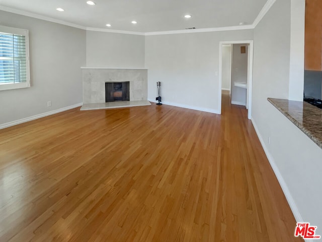 unfurnished living room featuring light wood-type flooring and crown molding