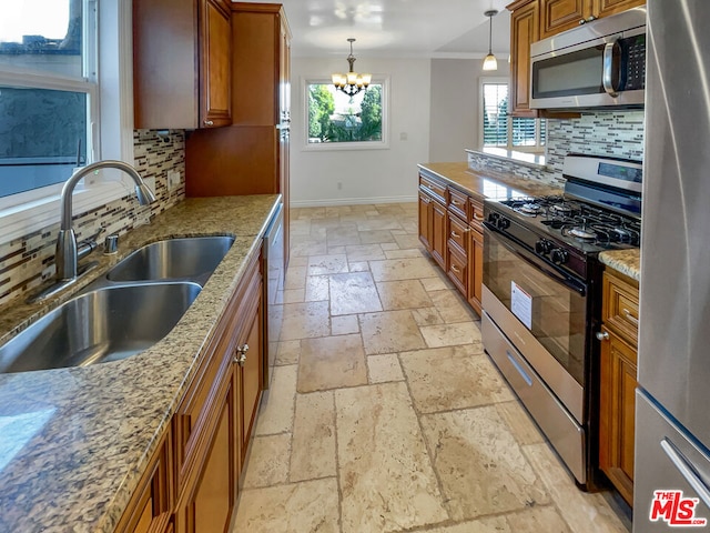 kitchen with decorative backsplash, stainless steel appliances, light stone countertops, and sink