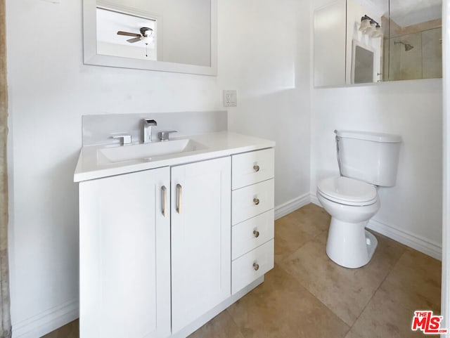 bathroom with tile patterned flooring, vanity, ceiling fan, and toilet