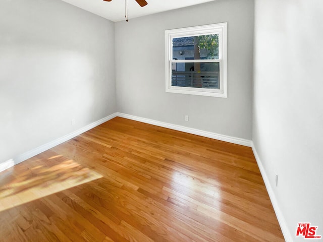 unfurnished room with ceiling fan and wood-type flooring