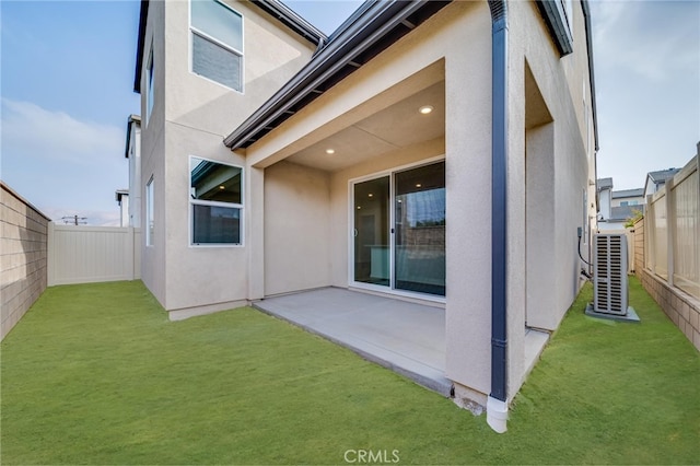 back of property featuring a yard, central AC, and a patio area