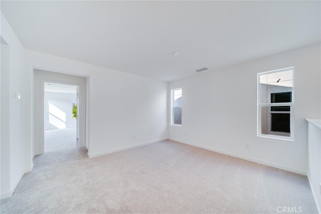 unfurnished room featuring light carpet