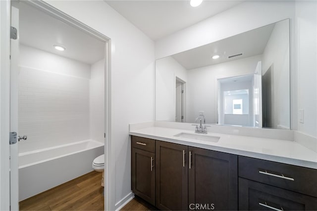 full bathroom featuring bathing tub / shower combination, toilet, vanity, and hardwood / wood-style flooring