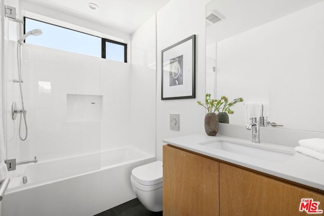 full bathroom with vanity, tiled shower / bath, and toilet